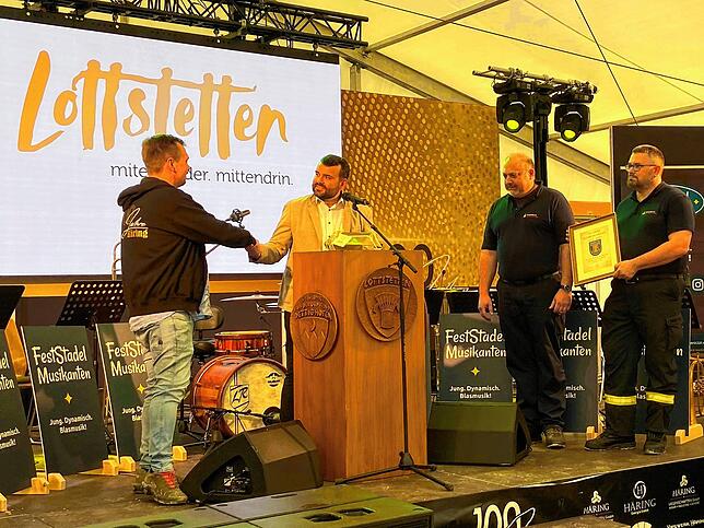 Bürgermeister Andreas Morasch gratuliert Denis Häring, links, zu dem besonderen Firmenjubiläum und überreichte ein Präsent. Kommandant ...