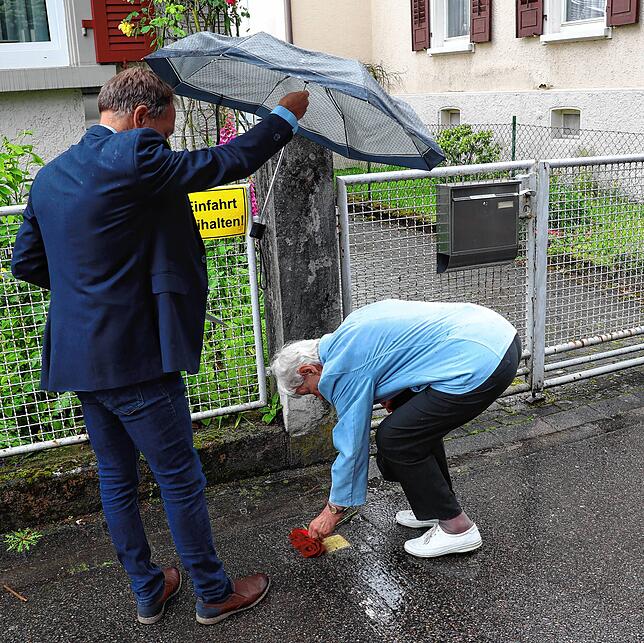 Klara Bosch legt Rosen am Stolperstein von Walter Hirt in der Marienstraße 3 nieder. Hans-Peter Storz von der Initiative Stolpersteine ...