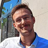Samuele Pampanin vor seiner Eisdiele. Genau auf dieser Höhe entsteht die Kante, vor der das Schild im Hintergrund warnt.