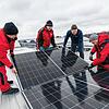 Auf einem Messedach werden PV-Module montiert.
