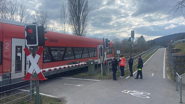 Ein Triebwagen steht auf dem geschlossenen Bahnübergang am Ortseingang von Ludwigshafen. Polizeibeamte sind am Kopfende des Fahrzeugs ...