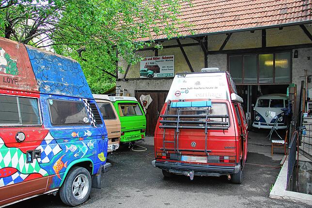 In der Scheune (hinten) repariert Helmut Peters die legendären Bulli und VW Käfer. Auf dem Hof warten schon die nächsten Autos auf ...