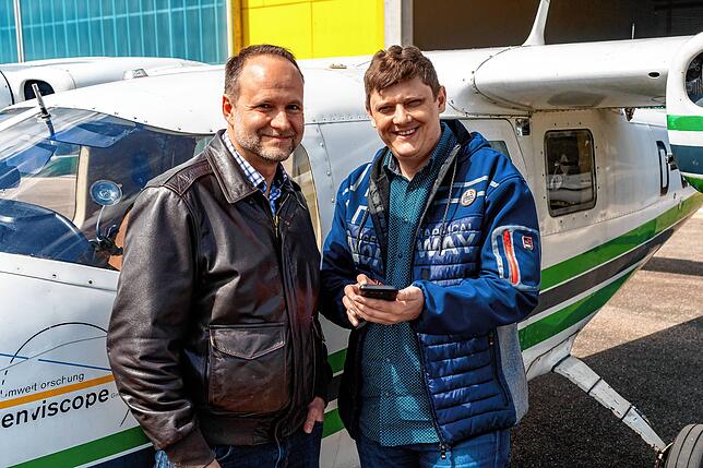 Softwareentwickler Roman Wehrle (rechts) erklärt dem Piloten Markus Duwe die neuen Funktionen Hagelabwehr-App auf seinem Smartphone.