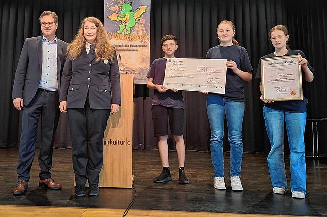 Urkunde und Scheck vom Bürgermeister nehmen stellvertretend Jugendfeuerwehrwartin Tanja Ehinger, Tim Eul, Hannah Bischoff und Lotta ...