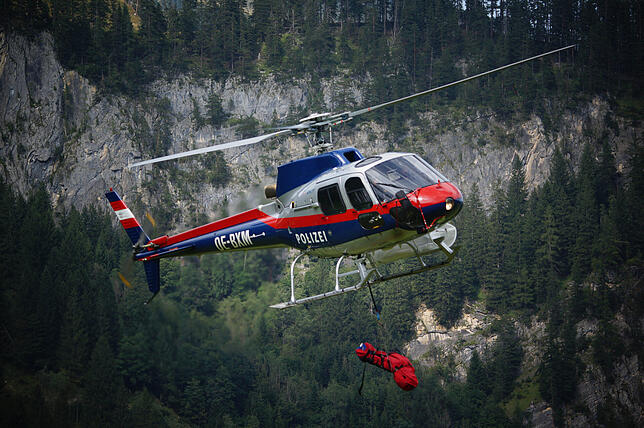 Ein Hubschrauber in den österreichischen Alpen fliegt einen Verunglückten ins Tal. In den Bergen steigt die Zahl der Rettungseinsätze ...