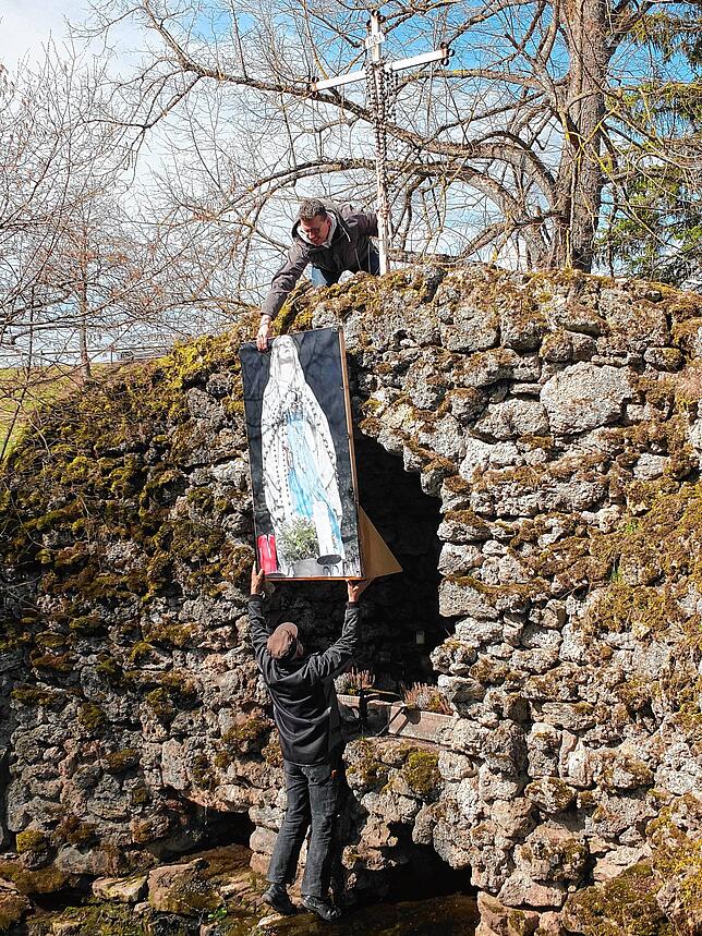 Stefan Fornal und Michael Käfer stellen die Ersatz-Madonna auf Leinwand in der Grotte auf.