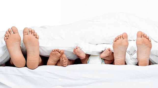 Mit dem Nachwuchs im Familienbett: Was harmonisch und liebevoll aussieht, ist für das Elternpaar der Lustkiller Nummer 1.