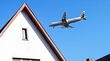 Ein Flugzeug fliegt über ein Haus (Symbolbild).