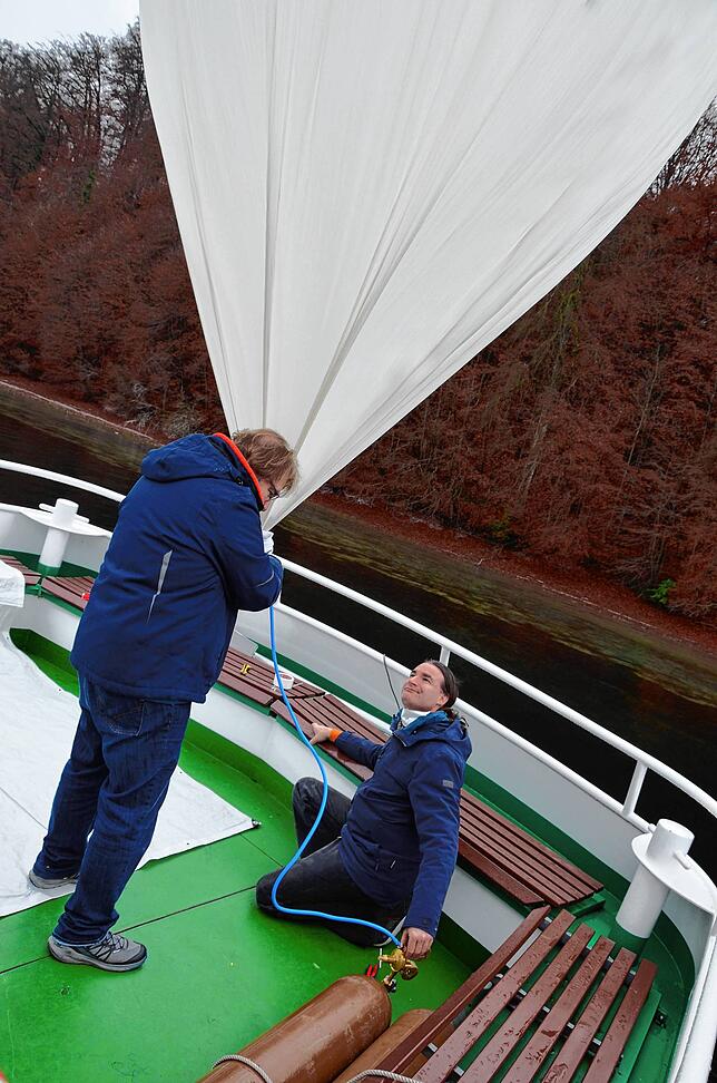 Achim Mende und Heiko Grebing, die für die Aktion zusammenarbeiten, befüllen den Ballon nach und nach mit Helium.