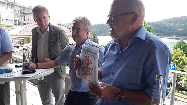 Diskussion auf der Kurhaus-Terrasse: Volker Haselbacher (rechts) vom Tourismusverband Hochschwarzwald zeigt eine Lärmkarte für den Süd-. ...