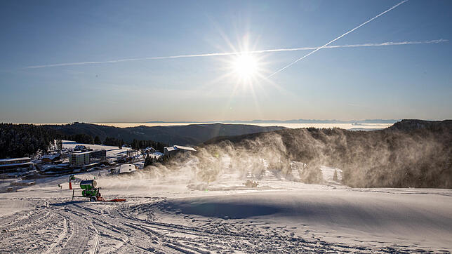 Eine Schneekanone beschneit eine Piste zwischen dem Feldbergturm und der Talstation der Feldbergbahn.