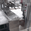 Eine Schere schneidet die Gummibänder zurecht, die die Maschine auf die Masken schweißt.