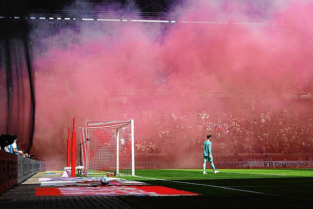 Frankfurts Torwart Kevin Trapp steht vor seinem Tor während dahinter eine dichte Rauchwand der Pyrotechnik der Frankfurter Fans zu sehen ...