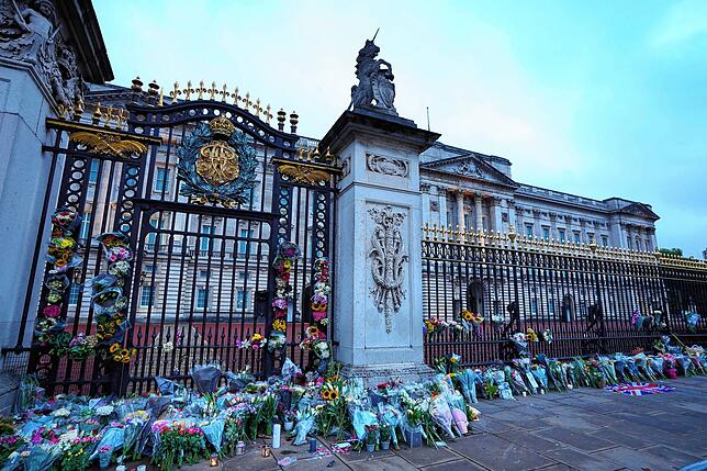 Blumen, Fahnen und Kerzen liegen vor dem Buckingham Palace.