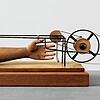 Eine im Rad gefangene Hand: Alberto Giacomettis &bdquo;Main prise&ldquo;, 1932. Holz und Metall, 20 x 59,5 x 27 Zentimeter.