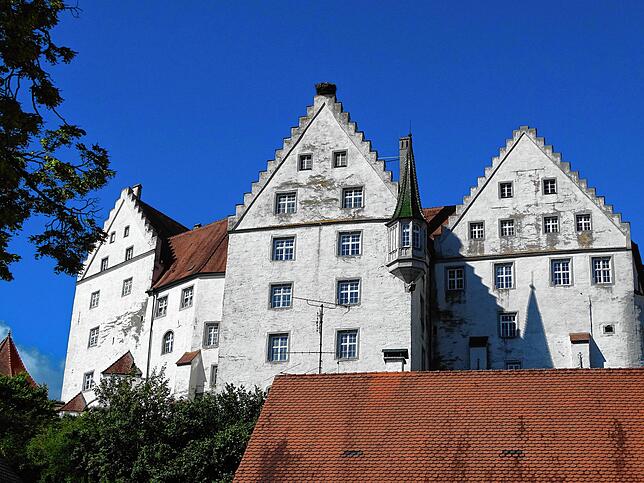 Schloss Scheer steht auf einem Felsen über der Donau. Es ist in Privatbesitz. Die Schlosskirche St. Nikolaus nebenan kann aber ...