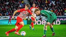 Freiburgs Noah Weißhaupt (l) und Gladbachs Luca Netz kämpfen um den Ball.