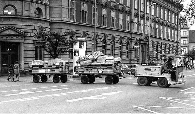 Erst Postkutsche, dann Elektrowagen: Dieses Fahrzeug mit Anhänger zeugt von der früheren Nutzung als Postgebäude.