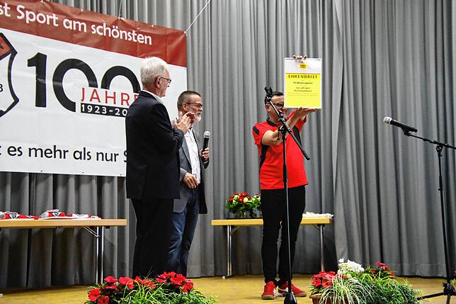 Der Vereinsvorsitzende Samir Vehabovic (rechts) hält die Auszeichnung des Südbadischen Fußballverbands in die Luft. Links ist der ...