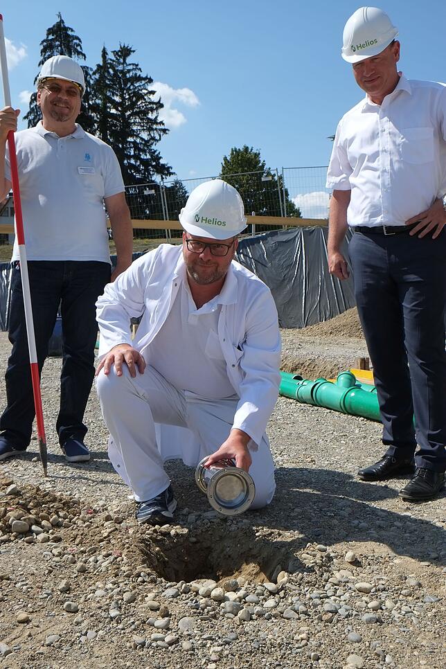 Chefarzt Marc Riemer vergräbt eine Zeitkapsel mit positiven Wünschen des Behandlungsteam am künftigen Standort der neuen Station.