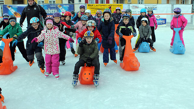 Schülerinnen und Schüler der zweiten Klassen der Eichbergschule flitzen voller Vergnügen über die Eisbahn.