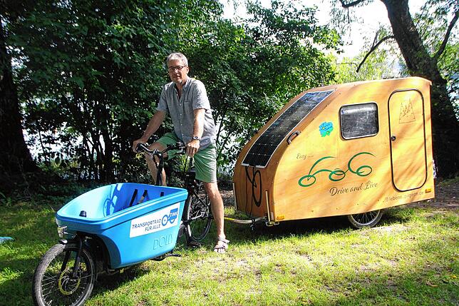 Ein Hingucker: Ein kleiner Holzwohnwagen gezogen von einem Elektro-Lastenrad. Marco Knöpfle hat ein Exemplar zum Ausleihen in Konstanz. ...