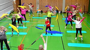 Eines von vielen Fitnessangeboten. Die Riegenleiterin Conny Gagliardi im Vordergrund macht die Übung mit Schwingstäben und Tüchern vor. ...