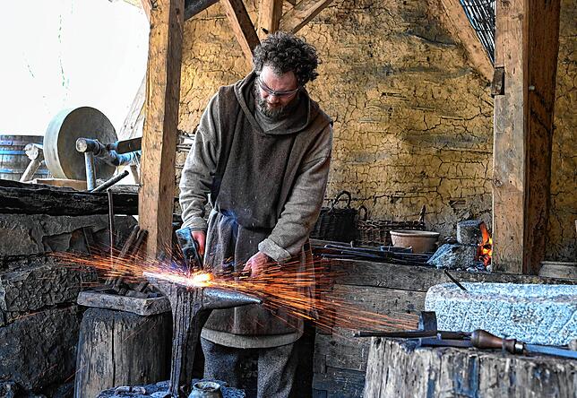 In der Schmiede wird der metallische Bedarf der Klosterbaustelle gefertigt. Hammer und Amboss müssen meist genügen.