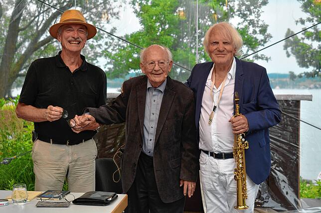 Den 90-jährigen Bruno Epple nehmen bei dessen Lesung auf der Landesgartenschau in Überlingen Moderator Oswald Burger (links) und ...
