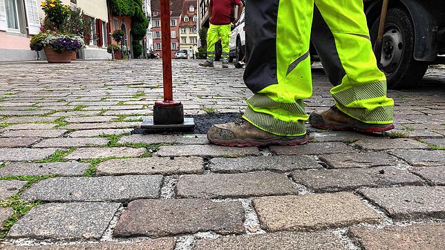 Ein Mitarbeiter einer Baufirma füllt in der Lindenstraße ein Asphaltgemisch ein. Hier waren zuvor lockere Pflastersteine.