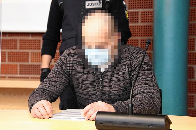 Der Angeklagte Michael K. blättert kurz vor Prozessbeginn durch die Ermittlungsakte.