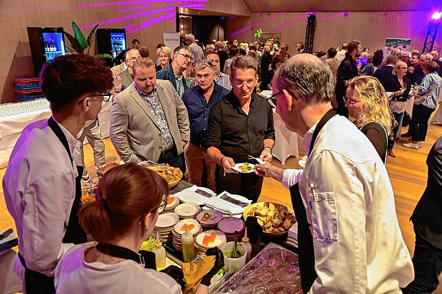 Guten Appetit: Tobias Maier reicht einem Gast seinen Teller mit leicht angerauchtem Saibling. Die Warteschlangen an den jeweiligen ...