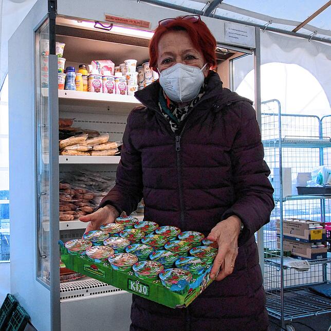 Doris Reuter sortiert im Zelt Molkereiprodukte und Fleischwaren in das Kühlregal.