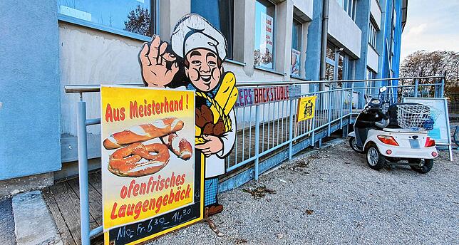 Mit einem Werbeschild an der Wilhelm-Binder-Straße wirbt Bäckermeister Adolf Heller für seine kleine Handwerksbäckerei.