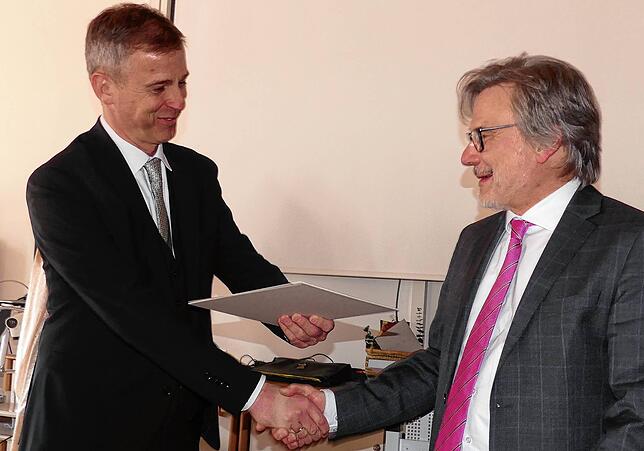 Ministerialdirektor Daniel Hager-Mann (links), überreicht Gernot Schultheiß die Entlasssungsurkunde.