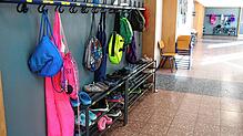 Rucksäcke und Jacken von Schülern hängen an der Garderobe einer Schule. In Weilheim müssen Eltern mehr für die Betreuung an der ...