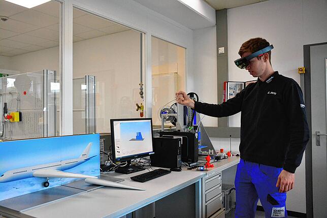 Julian Jurtz erlernt im 3. Ausbildungsjahr bei Diehl- Defense den Beruf des Industriemechanikers. Mit der HoloLens von Microsoft bewegt ...