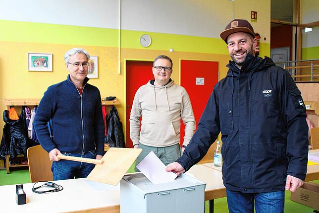 Tobias Bühler (rechts) wählt in Aftholderberg. Im Bild von links die Wahlhelfer Florian Irion und Wolfgang Schmid.