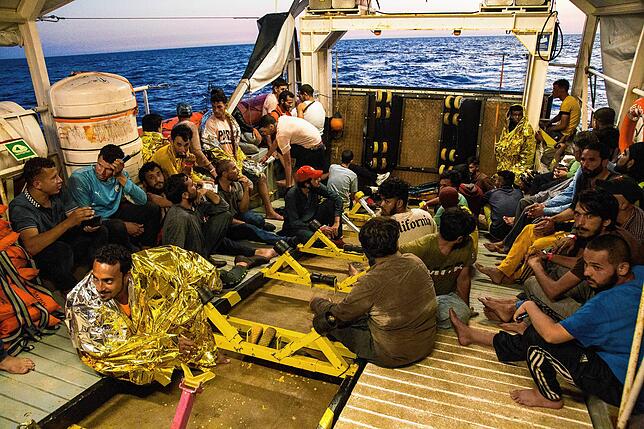 Diese Flüchtlinge wurden vor dem Ertrinken gerettet und von der Crew mit Wärmefolien und Schwimmwesten ausgestattet. Im Hintergrund das ...