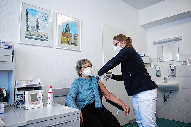 In einer Hausarztpraxis impft eine Hausärztin eine Patientin mit dem Impfstoff von Biontech.