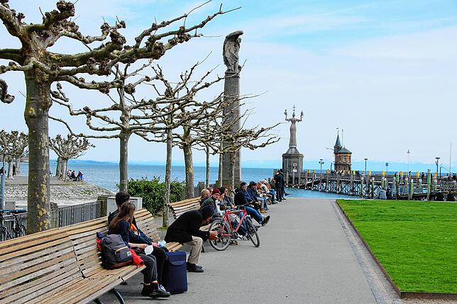 Konzilvorplatz am Ostermontag: Die Menschen sitzen verteilt auf den Bänken.