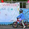 Ein Kindergartenkind steht vor seinem geschlossenen Kindergarten in Stuttgart.