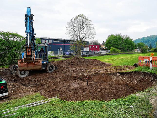 Ein Bagger bei Erdarbeiten am Ort des Wasserrohrbruchs. Im Hintergrund ist das Betriebsgelände der Firma Bau GmbH Herrischried zu sehen.