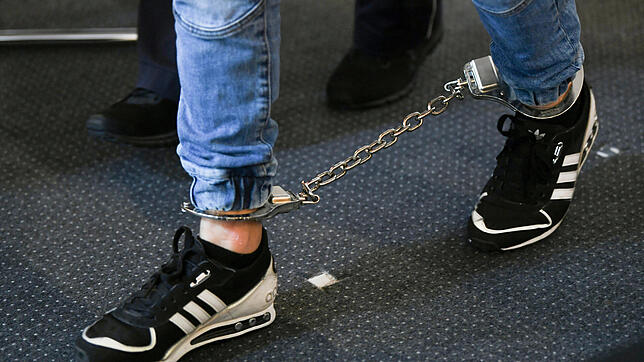 Ein Angeklagter kommt mit Fußfesseln in den Saal des Freiburger Landgerichts. Die elf Angeklagten sollen 2018 eine 18-Jährige vor einer ...