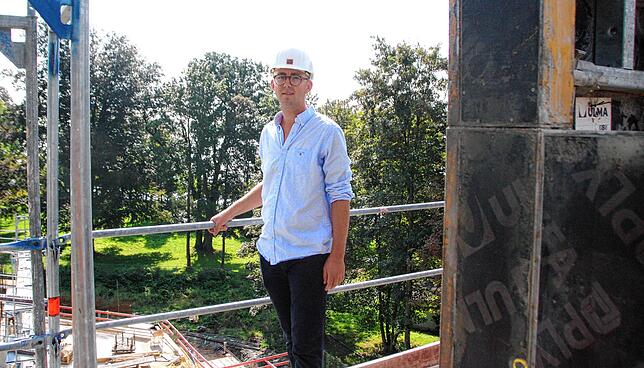 Jean Jacques Buff, der Sohn des Investors, demonstriert auf der höchsten Etage des Neubaus, dass von dort aus vor allem Bäume zu sehen ...