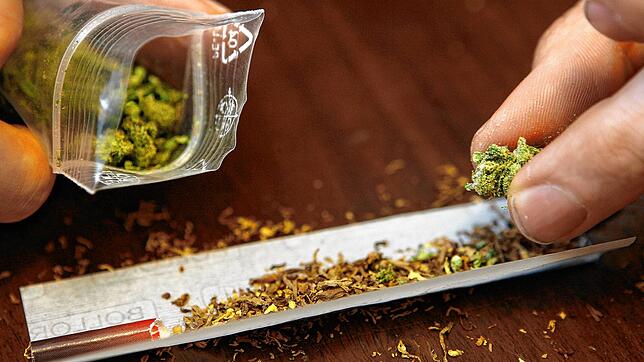 Ein Mann dreht sich einen Joint mit Marihuana.