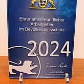 So kann sie jeder Mitarbeiter sehen: Eingerahmt hinter Glas steht die Auszeichnung auf dem Aktenschrank im Besprechungsraum.