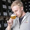 Braumeister Benedikt Wabnig riecht an einer seiner Bier-Kreationen.
