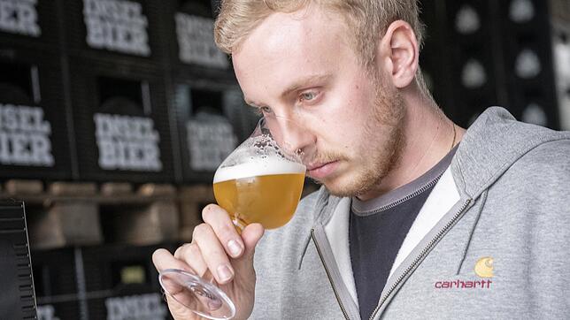 Braumeister Benedikt Wabnig riecht an einer seiner Bier-Kreationen.