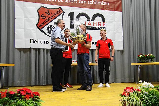 Ehrenmitglied Ralf Kempter bekommt von Beisitzer Alexander Bösch einen Obstkorb überreicht. Hinten stehen Samir Vehabovic (links) und ...